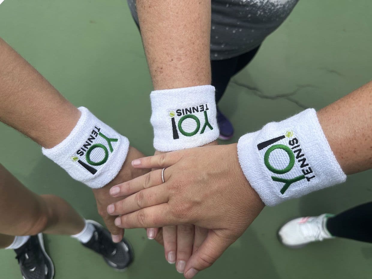 People holding hands,wearing yo tennis hand bands